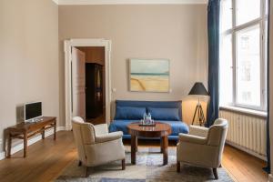 a living room with a blue couch and chairs at Hotel Art Nouveau am Kurfürstendamm in Berlin