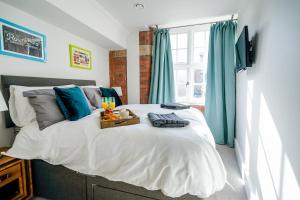 a bedroom with a large bed with blue curtains at Cocoa River - Quiet city centre, close to the Shambles, on the river, two bed, two bath, allocated parking in York