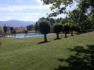 basen w parku z drzewami i trawą w obiekcie Camping Riaza w mieście Riaza