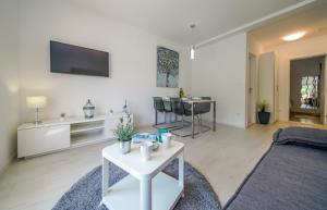 ein Wohnzimmer mit einem Tisch und einem TV an der Wand in der Unterkunft Apartmani Ponta in Ston