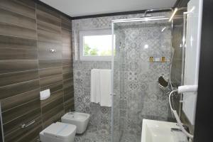 uma casa de banho com um chuveiro, um WC e um lavatório. em Apart Hotel Family em Sarajevo