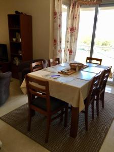 a dining room table with chairs and a large window at Sea view - top floor in Quarteira