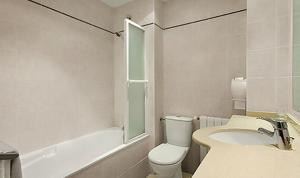 a bathroom with a sink and a toilet and a bath tub at H&ocirc;tel Icare in Toulouse