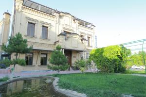 een groot gebouw met een vijver ervoor bij Boulevard Palace Hotel in Samarkand