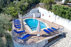 an overhead view of a swimming pool with chairs and umbrellas at Korakias Skorpidi in Yénion