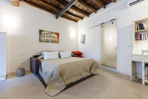 a white bedroom with a bed and a desk at Maison Romana Loft in Rome