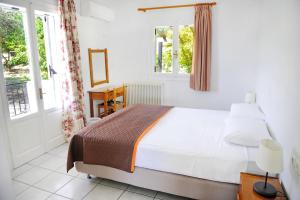 a bedroom with a bed and a desk and windows at Korakias Skorpidi in Yénion +46 photos