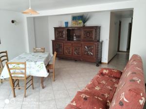 a living room with a couch and a table at Les Bananiers in Capbreton +3 photos