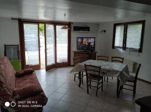 a living room with a table and chairs and a tv at Les Bananiers in Capbreton
