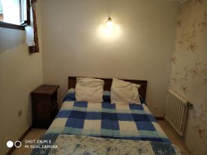 a bedroom with a bed with blue and white sheets at Les Bananiers in Capbreton