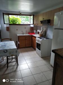 a kitchen with a white stove and a table at Les Bananiers in Capbreton