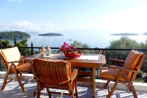 YénionにあるKorakias Skorpidiのテーブルと椅子、海の景色を望むバルコニー