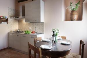 a kitchen with a wooden table with chairs and a dining room at PienzaLettings "Casa Olivieri" in Pienza