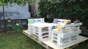 een tafel en stoelen op pallets in een tuin bij Gabi's Home #2 in Sighişoara