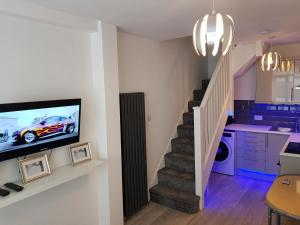 sala de estar con escalera y TV en la pared en Webb place 2 bedroom apartment !, en Croydon