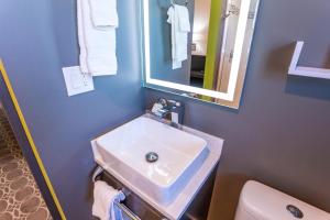 a bathroom with a sink and a toilet and a mirror at University Inn ASU/Tempe in Tempe