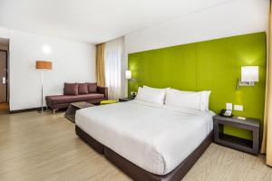 una habitación de hotel con una cama grande y una pared verde en Holiday Inn Express - Cartagena Bocagrande, an IHG Hotel, en Cartagena de Indias