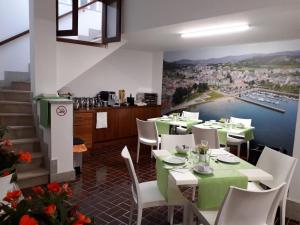 a restaurant with tables and chairs with a view of a harbor at Vendaval in Santa Marta de Ortigueira