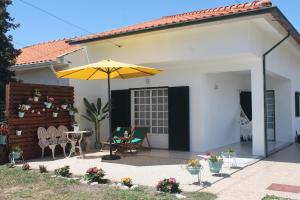 a patio with an umbrella and a table and chairs at Casa das Camélias in Aveiro