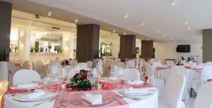a banquet hall with white tables and white chairs at Giulivo Hotel & Village in Baia Domizia +53 photos