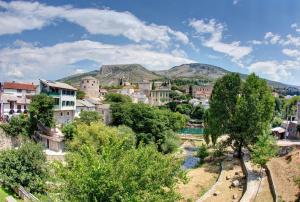 a city with a river and mountains in the background at Pansion Villa Nur in Mostar