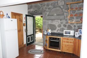 a kitchen with a stove and a refrigerator at Baía de Canas Villa in São Roque do Pico