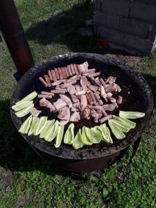 a grill with meat and vegetables cooking on it at Suri in Plužine