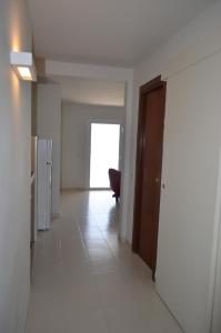 korytarz z drzwiami i krzesłem w budynku w obiekcie Apartaments Gibert w Sant Antoni de Calonge