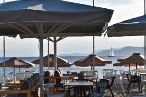 a group of tables and chairs with umbrellas on the beach at Evia Dream in Agiokampos