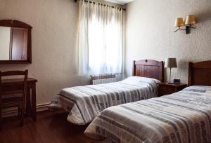 A bed or beds in a room at Hostal La Plaça