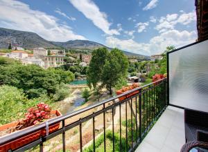 a balcony with a view of a town and mountains at Pansion Villa Nur in Mostar