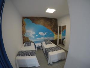 Habitación con 2 camas y un mural en la pared. en Apartamentos Juan Pérez- Viviendas Vacacionales, en Las Palmas de Gran Canaria