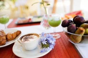 a table with a cup of coffee and a bowl of fruit at B&B Il Cavaliere Tropea in Santa Domenica