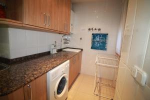 a small kitchen with a washing machine in it at Piso Vacacional en Murcia in Beniaján