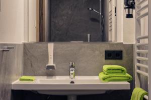a bathroom sink with green towels and a mirror at Brauerei Gaststätte Stierberg in Obertaufkirchen