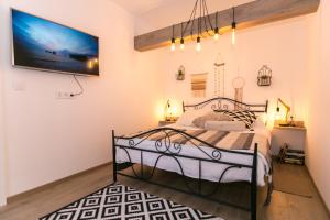 a bedroom with a bed and a tv on the wall at Apartments Del Molo in Rijeka