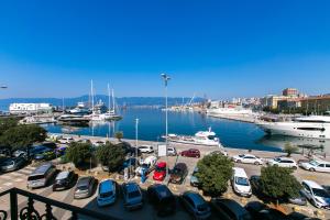 een parkeerplaats met auto's en boten in een jachthaven bij Apartments Del Molo in Rijeka