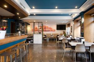 a restaurant with tables and chairs and a bar at Hotel Puerta Ciudad Rodrigo in Ciudad-Rodrigo