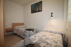 a room with two beds and a picture on the wall at Piso Vacacional en Murcia in Beniaján