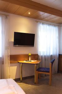 Zimmer mit einem Tisch und einem TV an der Wand in der Unterkunft Gästehaus Stögmüller in Asten