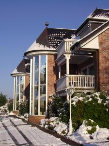 a brick house with a porch and a balcony at Ferienwohnungen Mantke SNF zertifiziert in Gronau