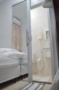 a bedroom with a mirror and a bed and a shower at Hostel Prime in Rio Verde +68 photos