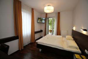 ein Schlafzimmer mit einem großen Bett und einem Fenster in der Unterkunft Hotel Goldene Gans in Mannheim