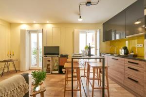 uma cozinha com um balcão e uma mesa com bancos em Lisbon Best Choice Apartments Alfama em Lisboa