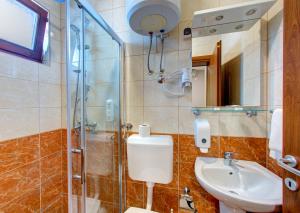 a bathroom with a shower and a toilet and a sink at Pansion Villa Nur in Mostar