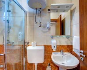 a bathroom with a toilet and a sink and a shower at Pansion Villa Nur in Mostar