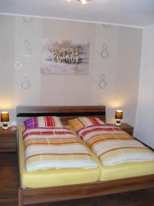 two beds in a bedroom with two lamps on the wall at Gasthof zum Lahntal in Laurenburg