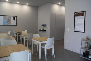 a dining room with tables and white chairs at StayInn City - Póvoa de Varzim in Póvoa de Varzim