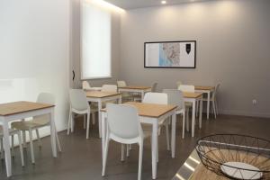 a dining room with wooden tables and white chairs at StayInn City - Póvoa de Varzim in Póvoa de Varzim