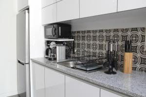 a kitchen with a sink and a microwave at StayInn City - Póvoa de Varzim in Póvoa de Varzim +16 photos